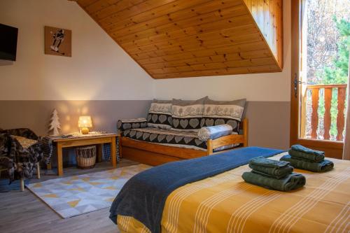 um quarto com uma cama e um sofá em Les Garianes em Saint-Léger-les-Mélèzes