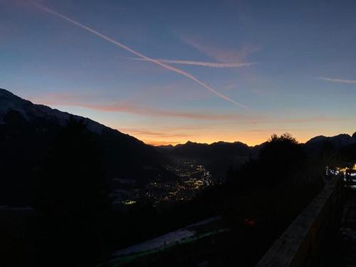 a view of a city from a mountain at sunset at NEST'L Appartements & Zimmer in Mösern