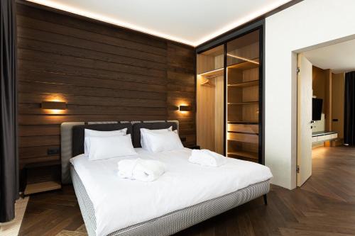 a bedroom with a white bed with two towels on it at Villas Fomich in Bukovel