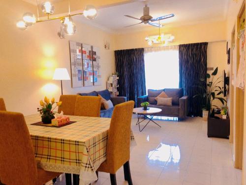 Una cocina y una sala de estar con mesa y sillas. en 101 Sky Mirror Homestay, en Kuala Selangor