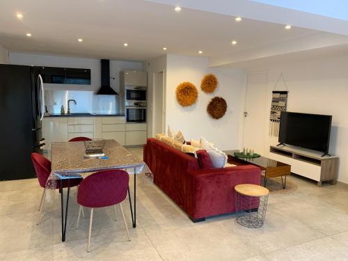 un salon avec un canapé rouge et une table dans l'établissement Appartement Centre ville Cassis, à Cassis