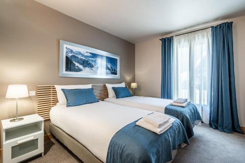 a bedroom with two beds and a window at Eden Hotel, Apartments and Chalet Chamonix Les Praz in Chamonix-Mont-Blanc