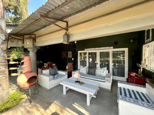 a patio with two couches and a table and chairs at Studio Kay in Benoni