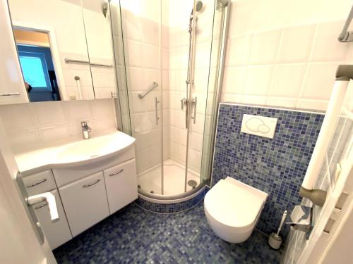 ein Badezimmer mit Dusche, Toilette und Waschbecken in der Unterkunft Max & Moritz, App 1 in Grömitz