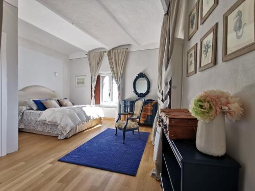 a bedroom with a bed and a blue rug at Between sky and sea in an exclusive village full of charm with a private terrace in Campiglia Marittima
