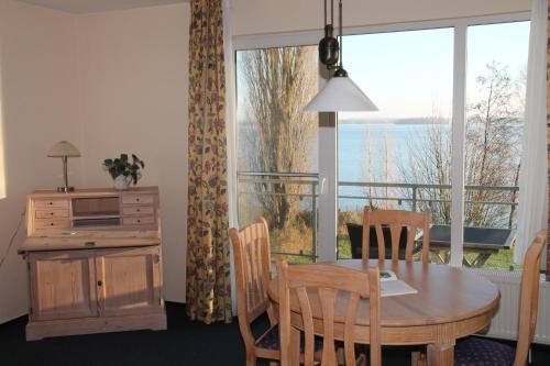 a dining room with a table and chairs and a large window at Fewo-Suite mit Seeblick in Ascheberg