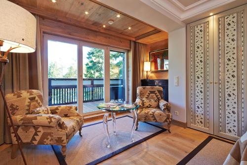 a living room with two chairs and a glass table at Alpin Resort Sacher in Seefeld in Tirol