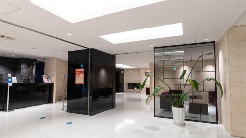 a lobby with a potted plant in a building at ibis Budget Osaka Umeda in Osaka