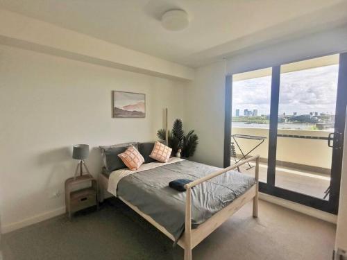 a bedroom with a bed and a large window at Unbeatable Water View in Sydney