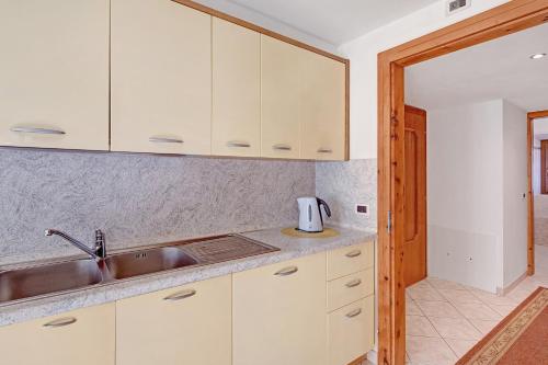 eine Küche mit weißen Schränken und einer Spüle in der Unterkunft Appartamenti Gg 2 in Livigno
