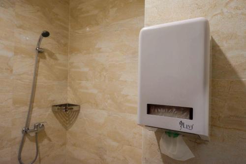a soap dispenser on the wall of a shower at Sans Hotel Empress Simpang Lima in Semarang