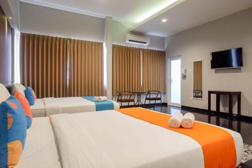 Postel nebo postele na pokoji v ubytování Sans Hotel Empress Simpang Lima