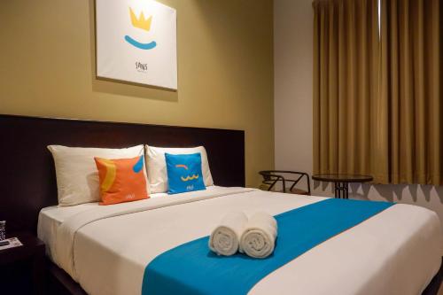 a bedroom with a large bed with towels on it at Sans Hotel Empress Simpang Lima in Semarang