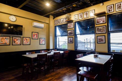 a restaurant with tables and chairs and a clock on the wall at Sans Hotel Empress Simpang Lima in Semarang