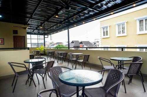 a group of tables and chairs on a balcony at Sans Hotel Empress Simpang Lima in Semarang