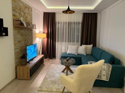 ein Wohnzimmer mit einem blauen Sofa und einem TV in der Unterkunft Milmari Apartman Haski N55 in Kopaonik