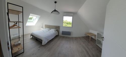 une chambre blanche avec un lit et un miroir dans l'établissement Le Clos des Cajaviris, à Carly