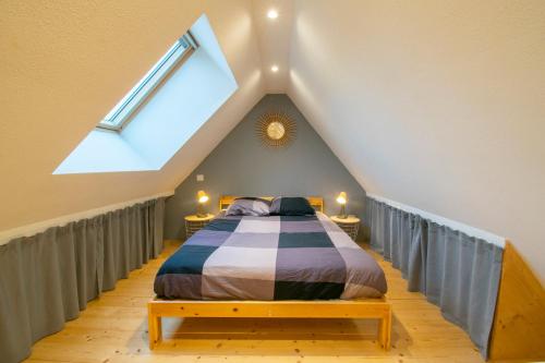 ein Schlafzimmer mit einem Bett im Dachgeschoss in der Unterkunft F2 201 neuf proche gare TGV, A36 et commerces in Botans