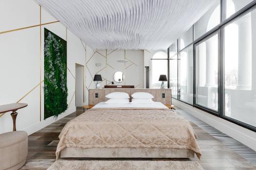 een slaapkamer met een groot bed en grote ramen bij Vladimir Hotel in Vladimir