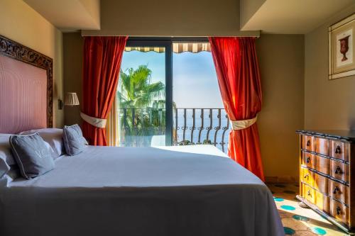 a bedroom with a bed and a large window at Hotel Villa Carlotta in Taormina