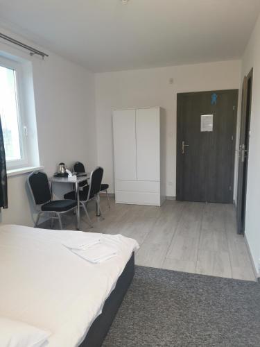 a room with a bed and a table and chairs at Pokoje Gościnne MAGNOLIA in Zalewo