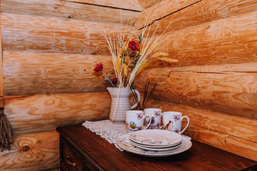 a table with two plates and a vase with roses at Soomaa Puhkeküla in Riisa