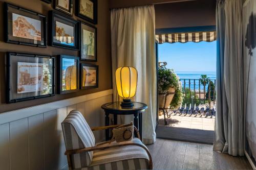 a living room with a lamp and a view of the ocean at Hotel Villa Carlotta in Taormina