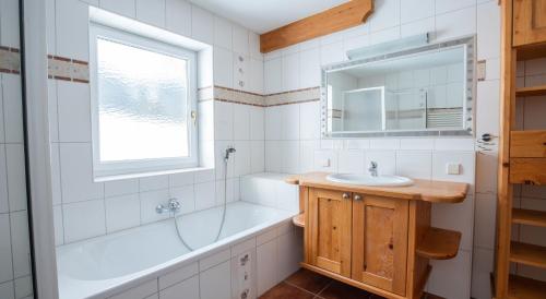 a bathroom with a tub and a sink and a mirror at Bio-Bauernhof Simonbauer in Ramsau am Dachstein