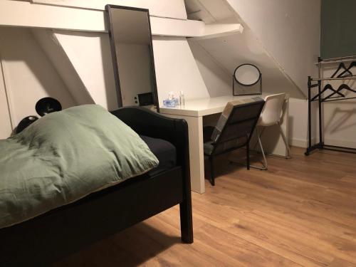a bedroom with a bed and a desk with a chair at City Center Enschede Homestay in Enschede