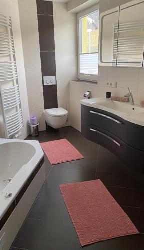 a bathroom with a tub and a sink and a toilet at Appartement Silbermond in Schladming