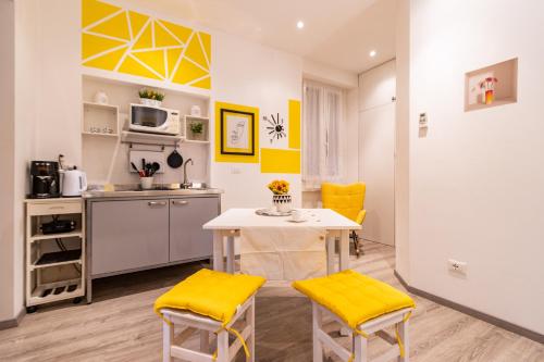 cocina con mesa y sillas amarillas en una habitación en Lemon Suite - Fiera Milano - City Life, en Milán