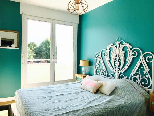 une chambre avec un lit avec un mur bleu dans l'établissement Proche Lac & vieille ville T3 avec grande terrasse, à Annecy