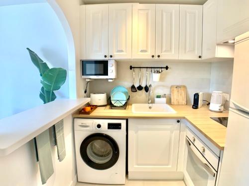 a kitchen with a washing machine and a microwave at StayMenorca Redescubre la paz in Son Parc