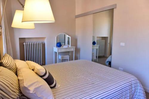 Schlafzimmer mit einem Bett, einem Tisch und einem Spiegel in der Unterkunft Attico d' amare in Ventimiglia