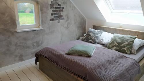 a bedroom with a bed with pillows and a window at Landlust Unser L ieblingscafe in Xanten