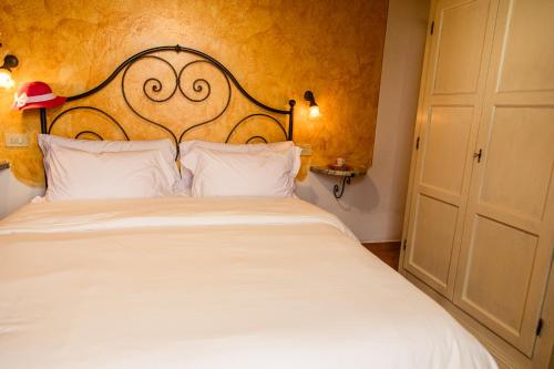 a bedroom with a white bed and a white door at Poggio del Sole in Castiglione del Lago