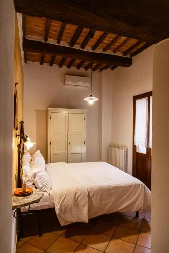 a bedroom with a large bed with white sheets and pillows at Poggio del Sole in Castiglione del Lago