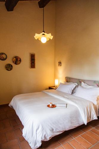 a bedroom with a large white bed with a plate on it at Poggio del Sole in Castiglione del Lago