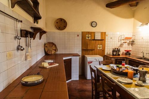 a kitchen with a counter and a table with chairs at Poggio del Sole in Castiglione del Lago