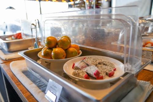 een buffet met een bord eten en een schaal fruit bij Grand Kokkod Khao Kho Resort in Khao Kho
