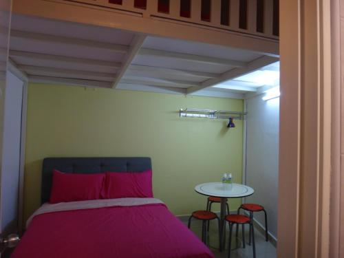a bedroom with a bed and a table with stools at Famosa 2 Stay in Melaka