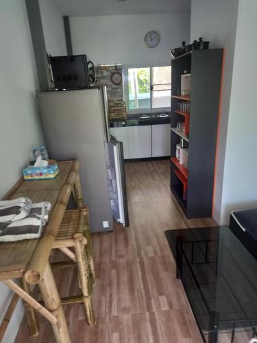 a kitchen with a wooden table and a refrigerator at sweet home phangan in Srithanu