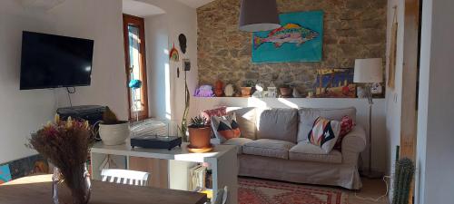 a living room with a couch and a tv at I Colori del Lago in Passignano sul Trasimeno