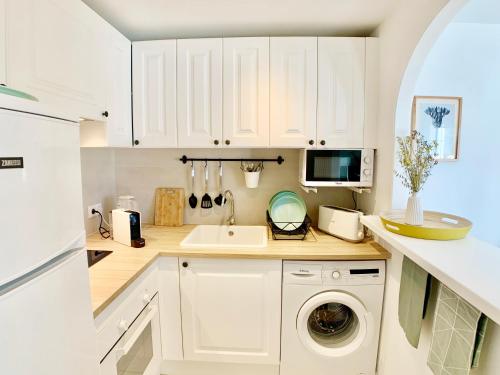 a kitchen with white cabinets and a washing machine at StayMenorca Escapa a la naturaleza in Son Parc