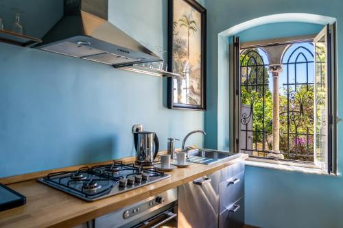 a kitchen with a stove and a sink and a window at Hotel Villa Carlotta in Taormina