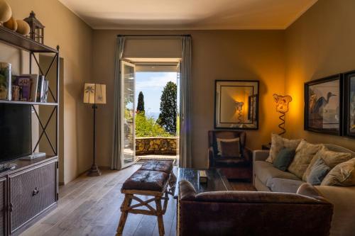 a living room with a couch and a tv at Hotel Villa Carlotta in Taormina