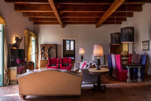 a living room with a couch and red chairs at Hotel Villa Carlotta in Taormina