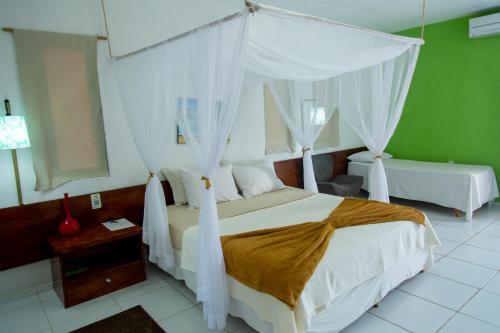 a bedroom with a bed with a canopy at Delta Park Hotel in Parnaíba