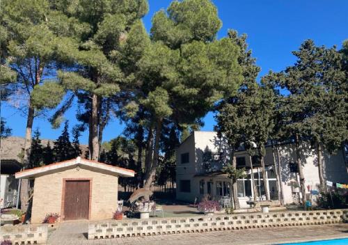a house with a pool and trees in the background at Habitacion en casa rural particular el Palomar in Villena