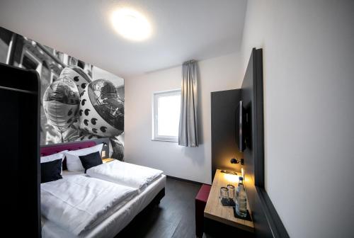 a bedroom with a white bed and a window at SMARTY Cologne Dom Hotel - Boardinghouse - KONTAKTLOSER SELF CHECK-IN in Cologne